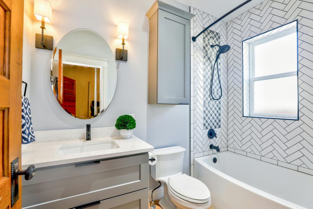 Elegant modern bathroom featuring chevron tiles, oval mirror, and sleek fixtures for a contemporary look. About lady greener